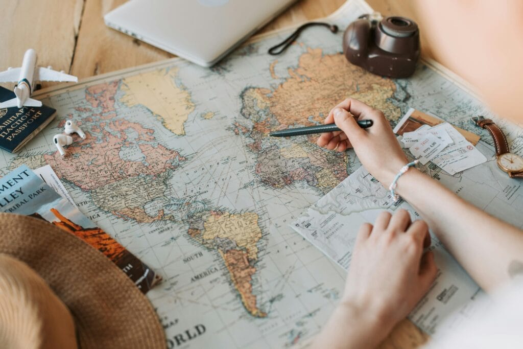 Pessoa planejando viagem pela Europa com mapa e passagens aéreas sobre a mesa. Viagem à Europa com orçamento limitado.
