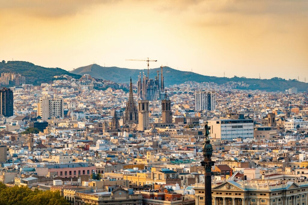 Vista da cidade de Barcelona ao entardecer com destaque para a Sagrada Família ao fundo. Viagem à Europa com orçamento limitado.