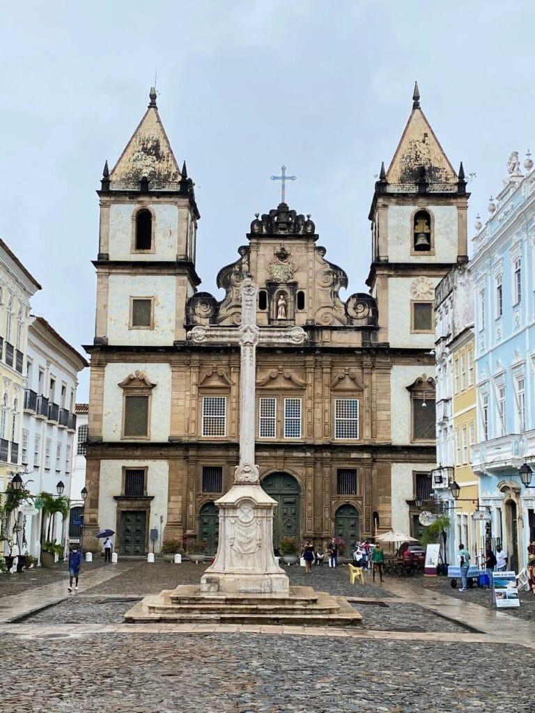 Fachada da Igreja de São Francisco no Pelourinho, com a cruz do Terreiro de Jesus em frente. Roteiro de 5 dias em Salvador.
