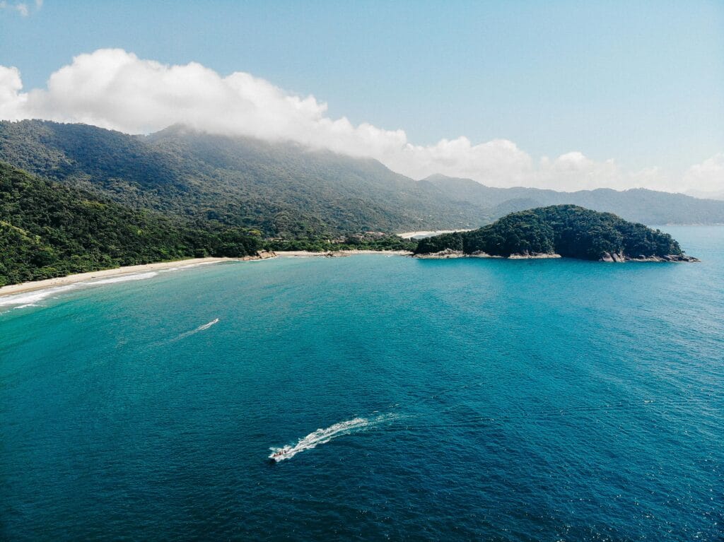 Vista aérea da imensidão do mar azul com a Ilha Grande ao fundo. Um dos destinos tendência mais bonitos do Brasil!