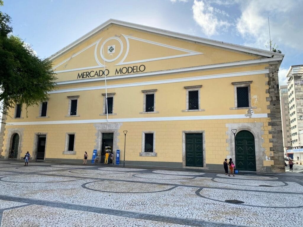 Fachada amarela do Mercado Modelo em Salvador, com céu azul e turistas na entrada. Roteiro de 5 dias em Salvador.