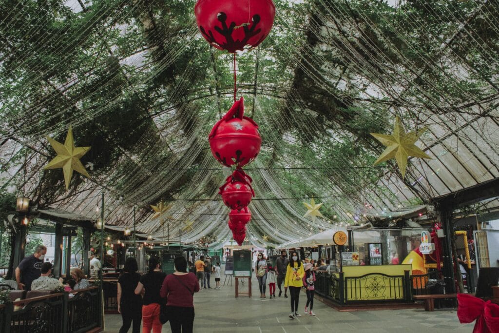 Rua Coberta em Gramado decorada com estrelas douradas e enfeites natalinos vermelhos durante o Natal Luz. O que fazer em Gramado?
