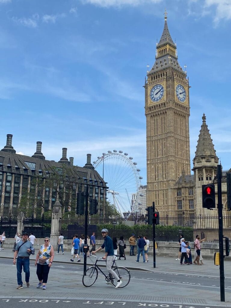 Big Ben e London Eye em Londres sob céu azul.
