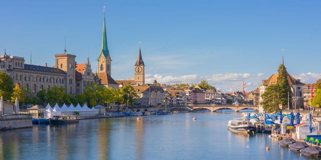 Vista do centro histórico de Zurique com o rio Limmat e igrejas ao fundo.