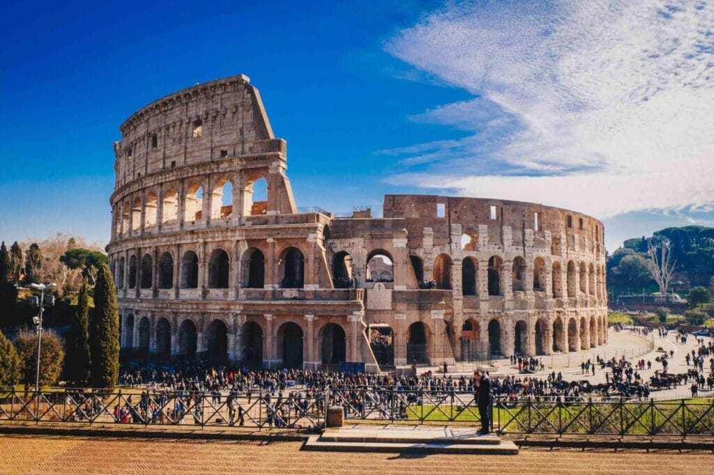Coliseu de Roma com céu azul ao fundo.