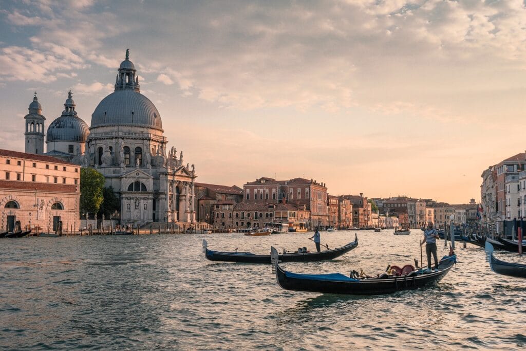 Gôndolas navegando no Grande Canal de Veneza ao por do sol.