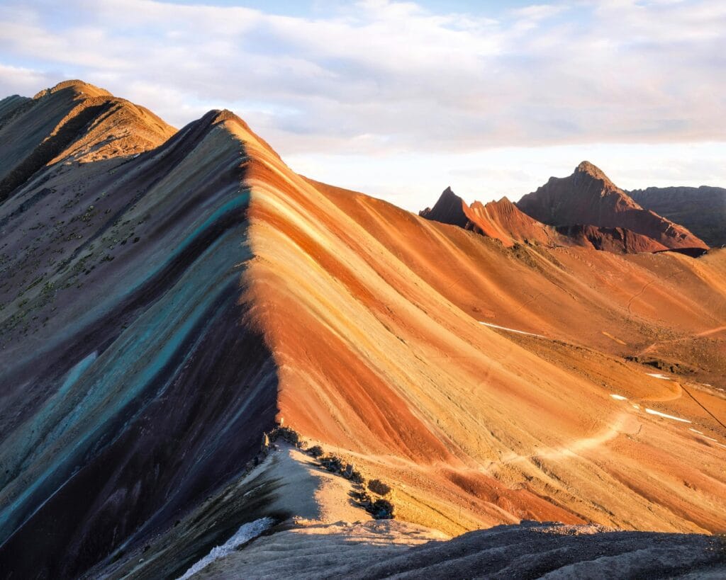 Montanha Arco-Íris no Peru, com faixas coloridas naturais iluminadas pela luz do sol