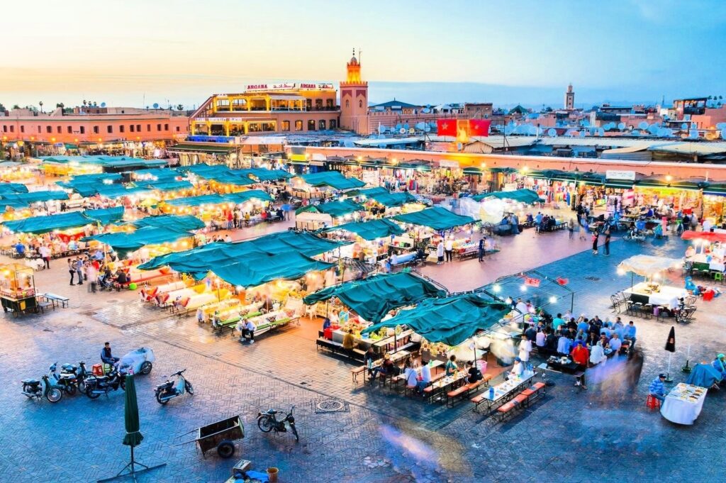 Vista aérea da Praça Jemaa el-Fna em Marrakech com luzes e barracas à noite.