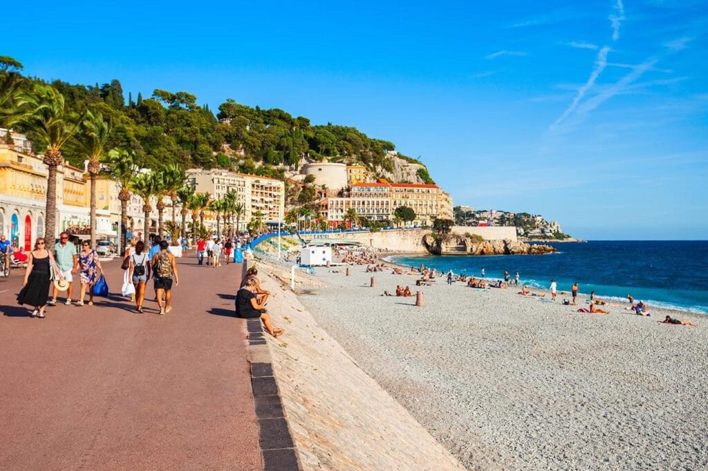 Promenade des Anglais com praia e turistas em Nice.