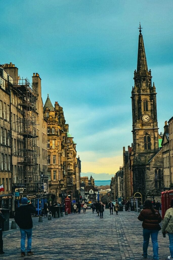 Rua Royal Mile em Edimburgo, com arquitetura histórica e turistas passeando.