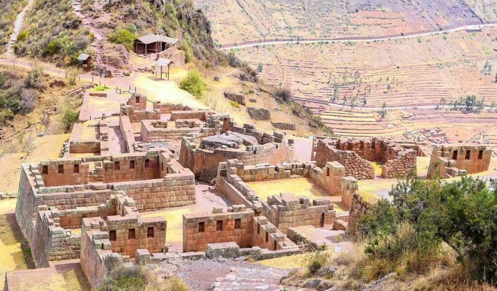 Ruínas incas de Pisac em destaque com terraços agrícolas ao fundo, no Vale Sagrado