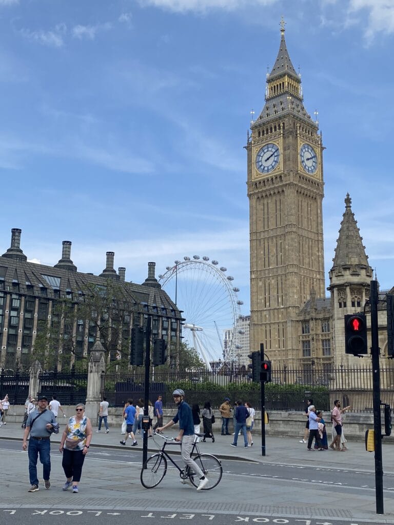 Big Ben com a London Eye ao fundo vistos da calçada em Westminster