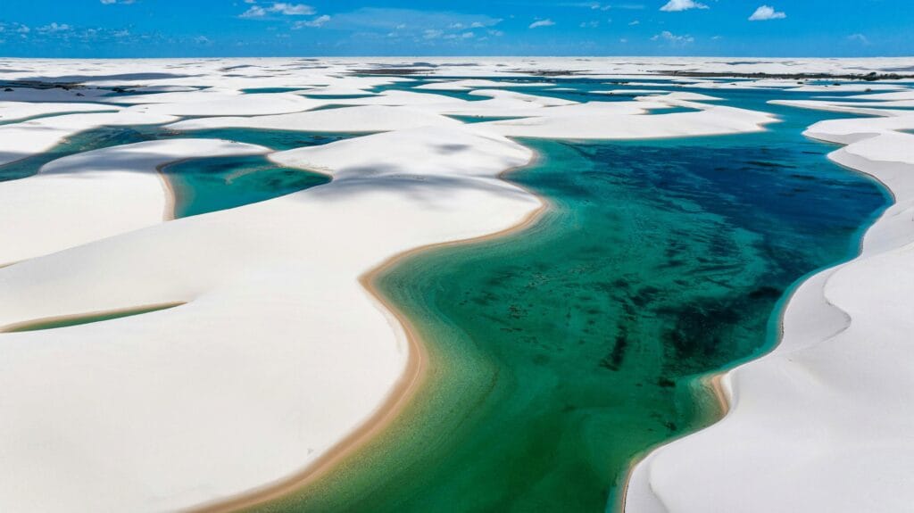 Vista aérea das dunas brancas e lagoas cristalinas do Parque Nacional dos Lençóis Maranhenses, no Maranhão. Planeje e curta os Lençóis Maranhenses sem erro!