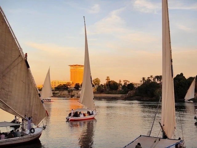 Felucas navegando no Rio Nilo durante o pôr do sol em Aswan, Egito. Roteiro de 10 dias pelo Egito.