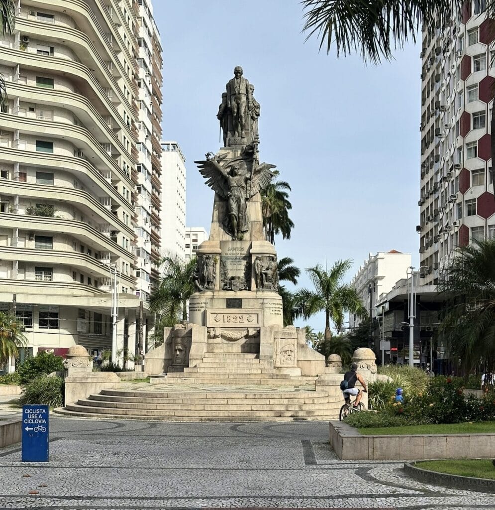 Vista frontal do Monumento aos Andradas na Praça da Independência em Santos, com ciclovia e prédios ao redor – melhores pontos turísticos de Santos.