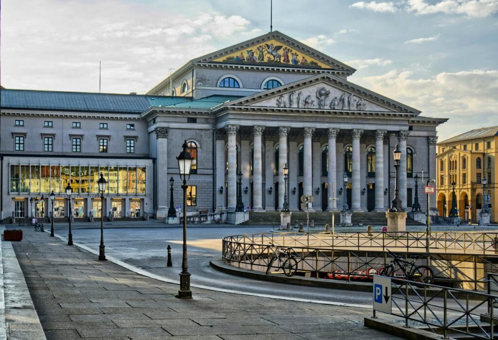Fachada do Teatro Nacional de Munique com colunas coríntias e frontão clássico ao entardecer, refletindo a arquitetura histórica da cidade. Roteiro de 5 dias em Munique.