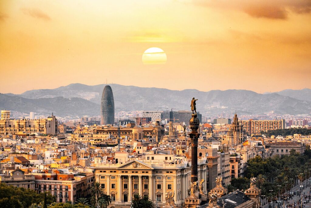 Vista panorâmica ao pôr do sol para o Roteiro de 3 dias em Barcelona, com o Monumento a Colombo em destaque e a Torre Glòries ao fundo
